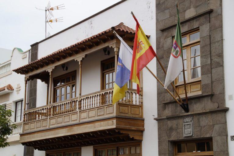 balkon z drewna, architektura kolonialna, 3 flagi: Wysp Kanaryjskich, Hiszpanii oraz miasta na Teneryfie